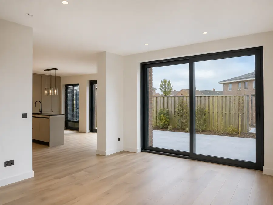 Afgewerkte uitbouw van binnen, met houten vloer en doorkijk naar de keuken.
